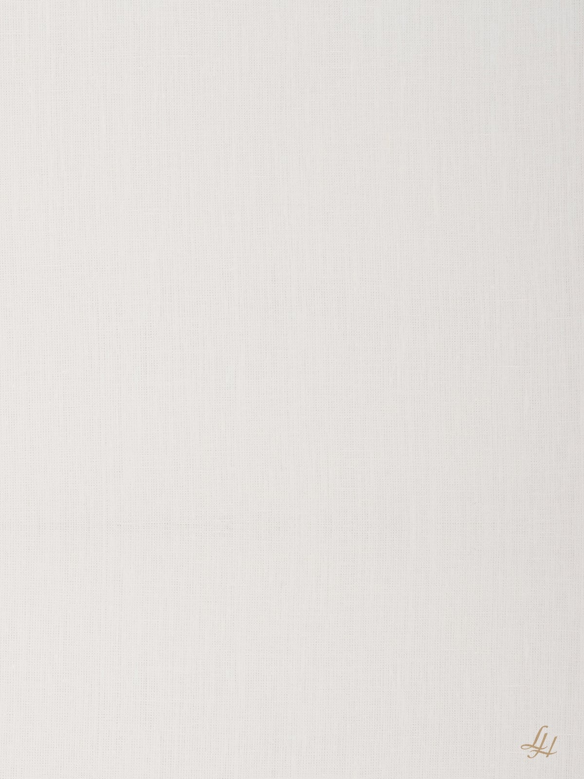 Ein weißer, strukturierter Stoff mit einem schwachen Gittermuster und einem kleinen goldenen H-Monogramm in der rechten unteren Ecke.
