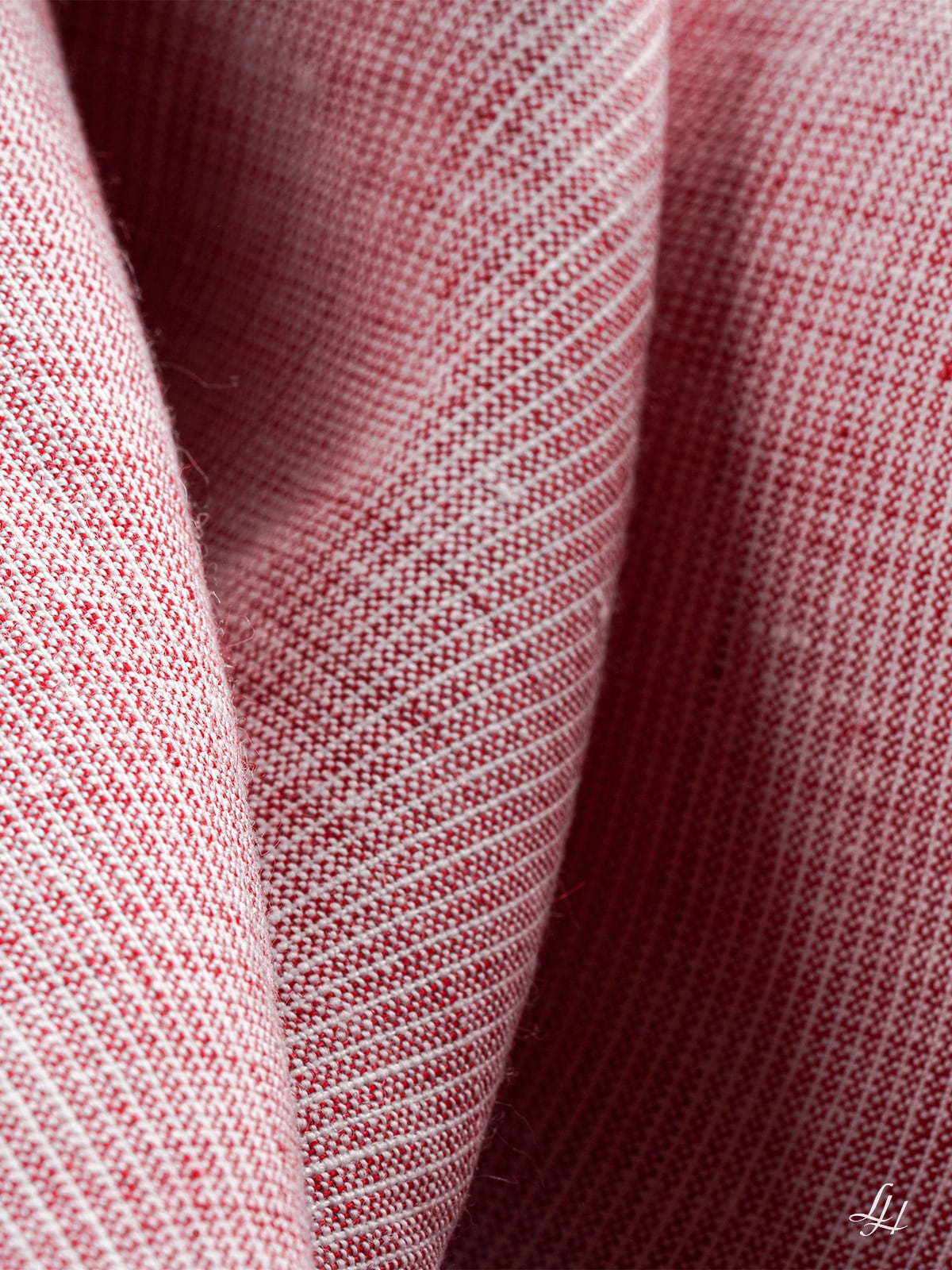 Nahaufnahme eines rosaroten und weißen europäischen Flachsgewebes mit sichtbarer Textur und diagonalen Mustern.