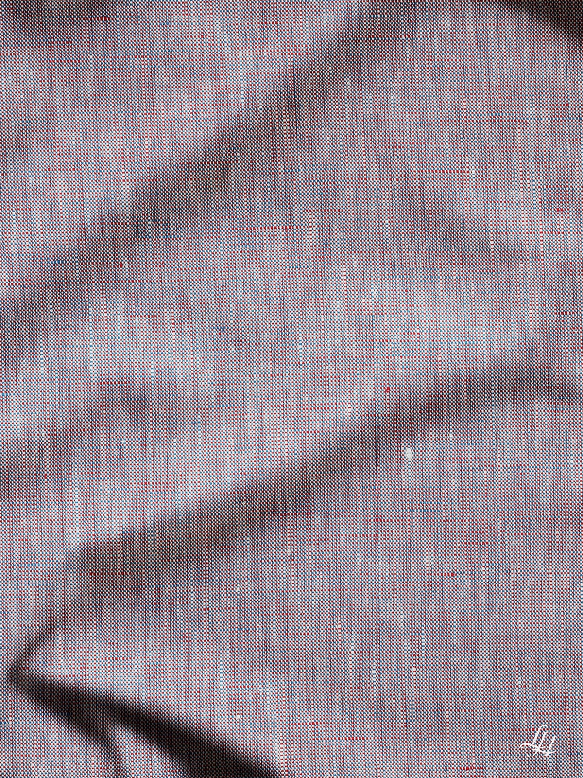 Nahaufnahme eines hypoallergenen Leinen-Kissenbezugs, der faltigen grauen Stoff mit roten und blauen Fäden zeigt, hergestellt in Deutschland.