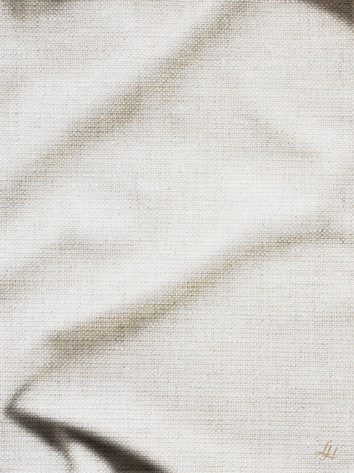 Natürlich strukturiertes Reinleinengewebe mit sichtbarer Bindung, weichen Falten, sanften Schatten und einer hypoallergenen Oberfläche.