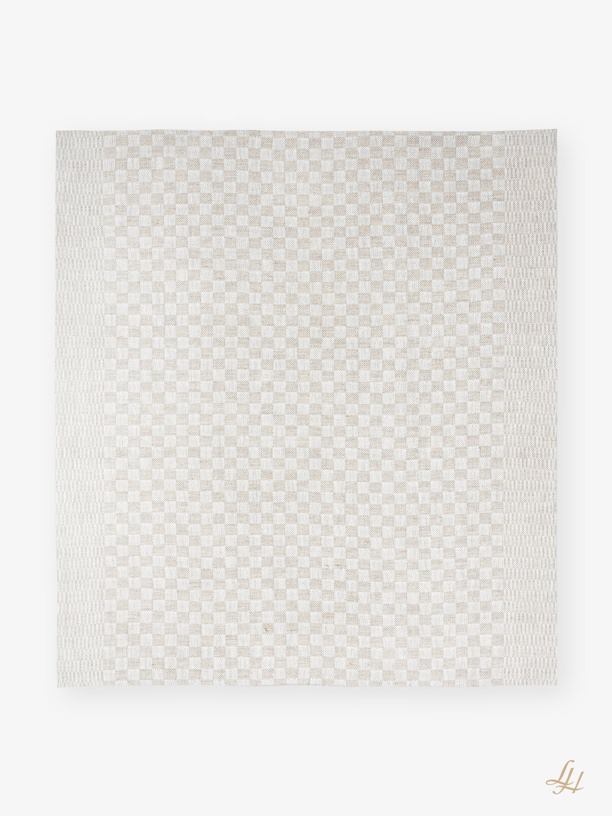 Ein rechteckiger, beige-weiß karierter Teppich, der an ein kariertes Küchentuch erinnert, mit strukturierten Rändern, auf weißem Grund.