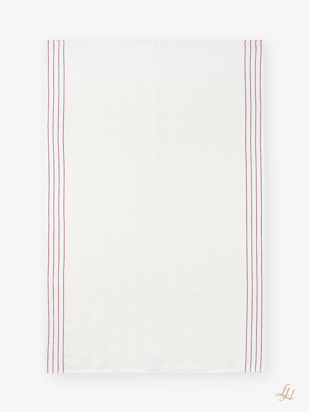 Ein weißes Halbleinen-Geschirrtuch mit roten Streifen und einem goldenen Monogramm - zeitlose, hochwertige Küchentextilien.