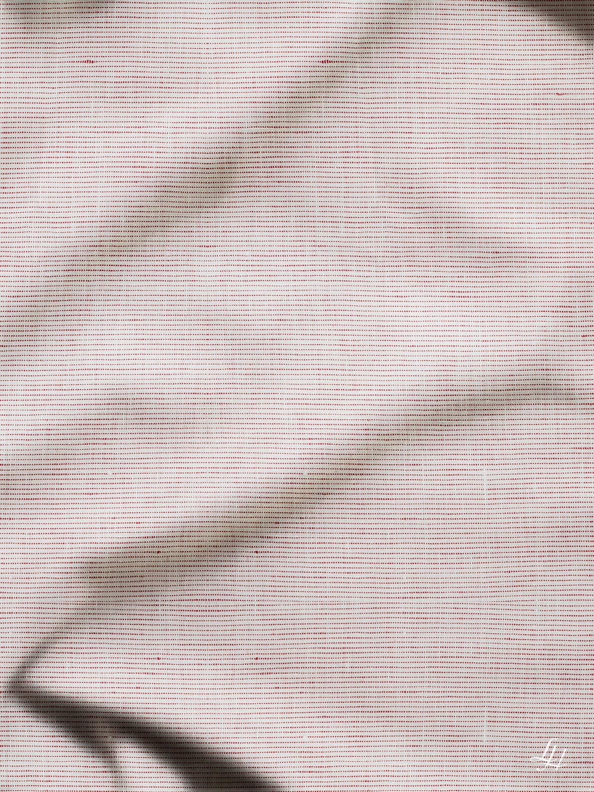 Eine Nahaufnahme von Leinenbettwäsche in hellem Beige, die traditionelle Webkunst und weiche, schattenhafte Falten zeigt.