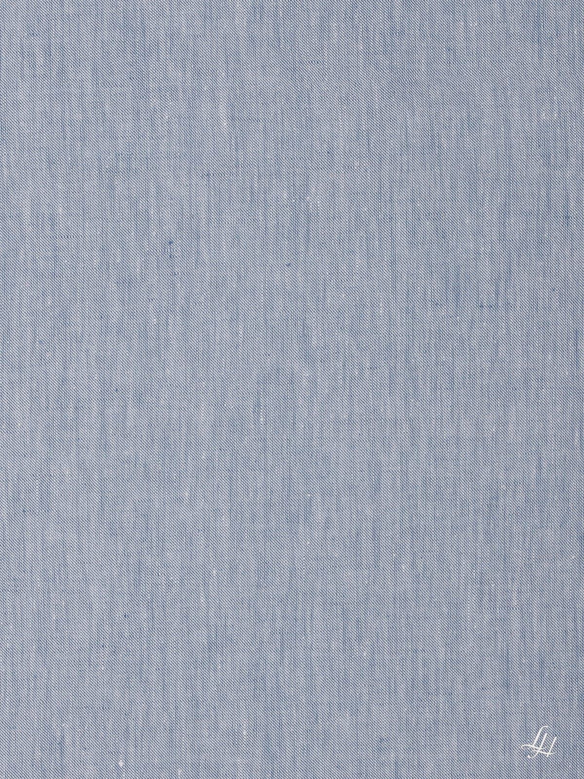 Altblauer Stoff mit dezentem Leinenmuster und einem kleinen weißen, aufgenähten Logo in der rechten unteren Ecke.